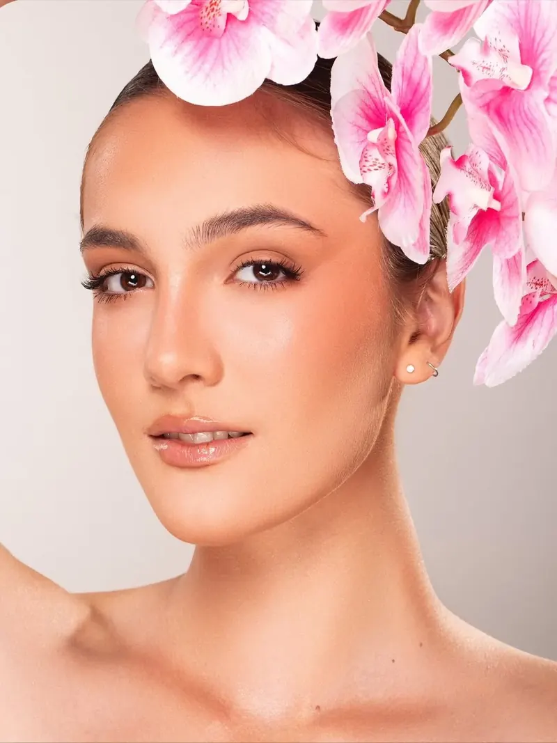 Beleza editorial com orquídeas cor-de-rosa no cabelo
