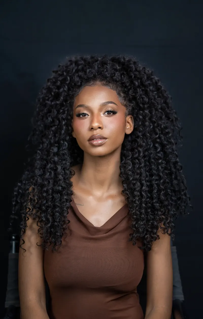 Cabelo cacheado volumoso e maquiagem natural em estúdio