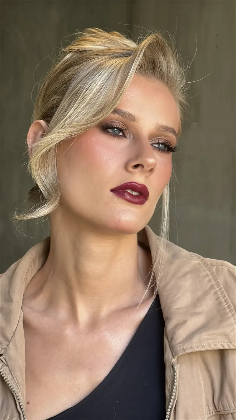 Penteado preso com textura e maquiagem editorial com lábios vinho